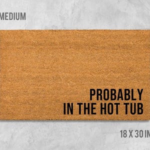 A rectangular, light brown doormat with the text "Probably in the hot tub" printed on it.