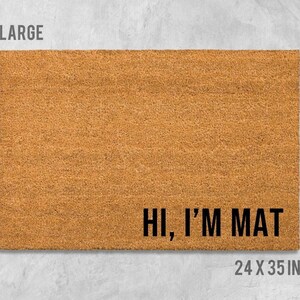 A large rectangular welcome mat with the text "HI, I'M MAT" printed on it.