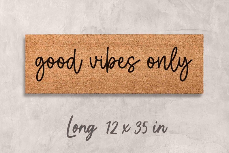 A rectangular wooden door mat with the text "good vibes only" written on it.