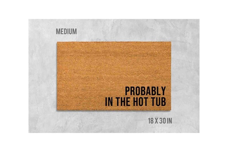 a rectangular, textured door mat with the text "Probably in the hot tub" printed on it.