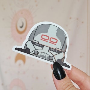 Könnte beinhalten: Ein weißer und grauer Aufkleber mit einem Cartoon-Stormtrooper mit roten Markierungen auf seinem Helm. Der Aufkleber befindet sich auf einem weißen Hintergrund.