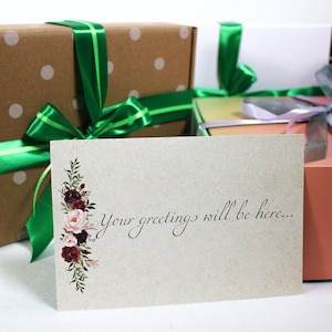 May include: A card with a floral design and the text "Your greetings will be here..." on a brown background. The card is in front of three wrapped gifts with green, purple, and brown ribbon.