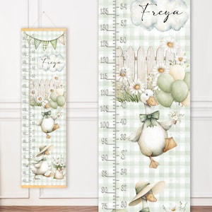 May include: A whimsical height chart featuring a duck illustration with a green bow, holding balloons. The chart has a gingham background, daisies, and a wooden fence. The name "Freya" is written in script. Measurements are in inches.