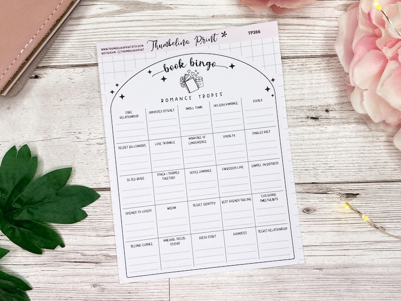 May include: A printable book bingo card with a black and white design. The card features a list of romance tropes, including "fake relationship", "enemies to lovers", "love triangle", and "second chance".