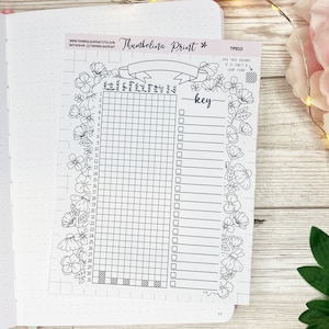 May include: A black and white printable planner page with a floral border. The page is divided into a grid with 31 squares and a key with blank lines. The text "Thumbelina Print" and "TP010" are at the top of the page.