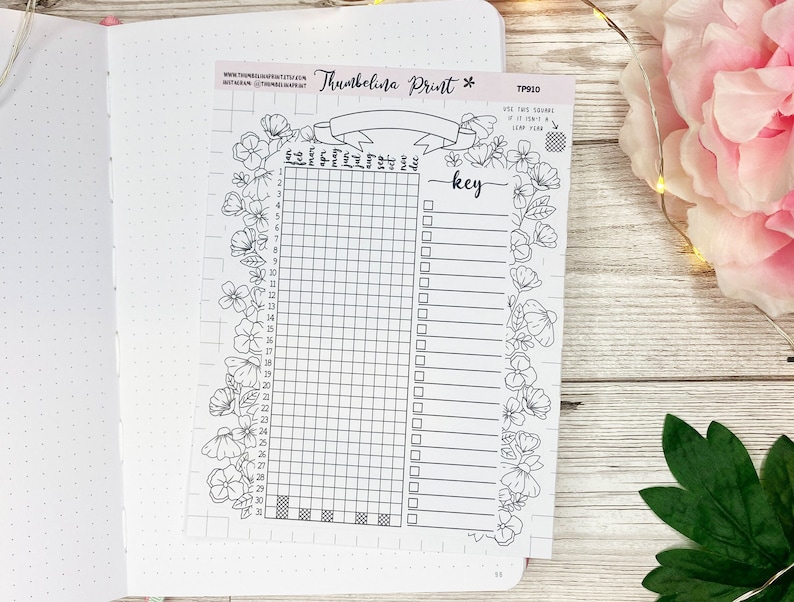 May include: A black and white printable planner page with a floral border. The page is divided into a grid with 31 squares and a key with blank lines. The text "Thumbelina Print" and "TP010" are at the top of the page.