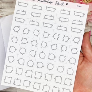 May include: A sheet of black and white planner stickers featuring a variety of shapes, including rectangles, hexagons, and circles. The stickers are designed for use in organising and decorating planners.