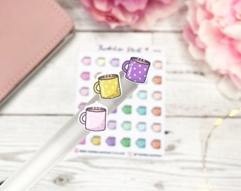 May include: Three colorful coffee cup stickers with white polka dots. The stickers are on a clear plastic sheet and are ready to be used in a planner or journal.
