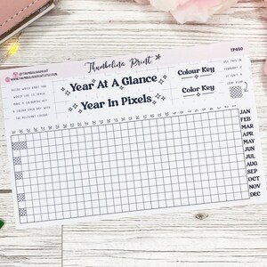 May include: A printable year at a glance and year in pixels tracker. The tracker is a grid with 12 rows and 31 columns. The months of the year are listed on the right side of the grid. The text "Year at a Glance" and "Year in Pixels" is at the top of the grid. The text "Colour Key" is at the top right of the grid.