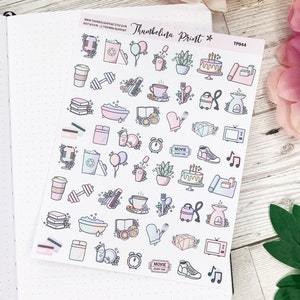 May include: A sheet of stickers with various illustrations, including a microphone, a coffee cup, a dumbbell, a bathtub, a plant, a cake, a yoga mat, a book, a credit card, a pair of oven mitts, a diamond, a television, a movie ticket, a sneaker, and musical notes. The stickers are on a white background and have a pastel color scheme.