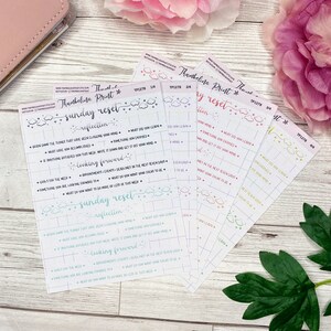 Puede incluir: Un conjunto de cinco pegatinas de planificador imprimibles de colores con el texto "Sunday Reset" y "Weekly Reset" en una fuente de escritura a mano. Las pegatinas est&aacute;n decoradas con nubes y estrellas.