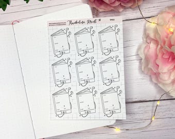 May include: A sheet of stickers featuring a black and white illustration of a book with headphones. The stickers have a grid background and the text "Thumbelina Print" at the top. The stickers are on a white dotted paper.