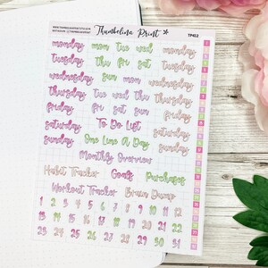 May include: A sheet of colorful planner stickers with days of the week, calendar numbers, and phrases like "To Do List" and "Brain Dump".