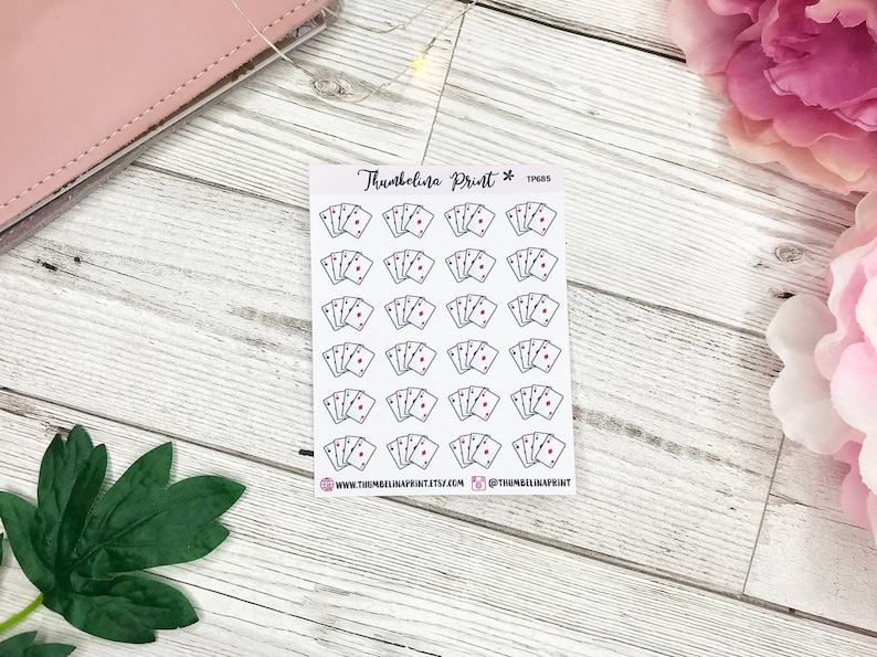 May include: A sheet of 25 stickers featuring a simple line drawing of four playing cards with a red heart on each card. The stickers are white with black outlines and are arranged in five rows of five stickers. The text "Thumbelina Print*" and "TP465" is printed in the top right corner of the sheet.