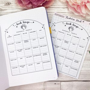 May include: A printable book bingo card with a black and white design. The card features a list of romance tropes, including "fake relationship", "enemies to lovers", and "forced proximity".