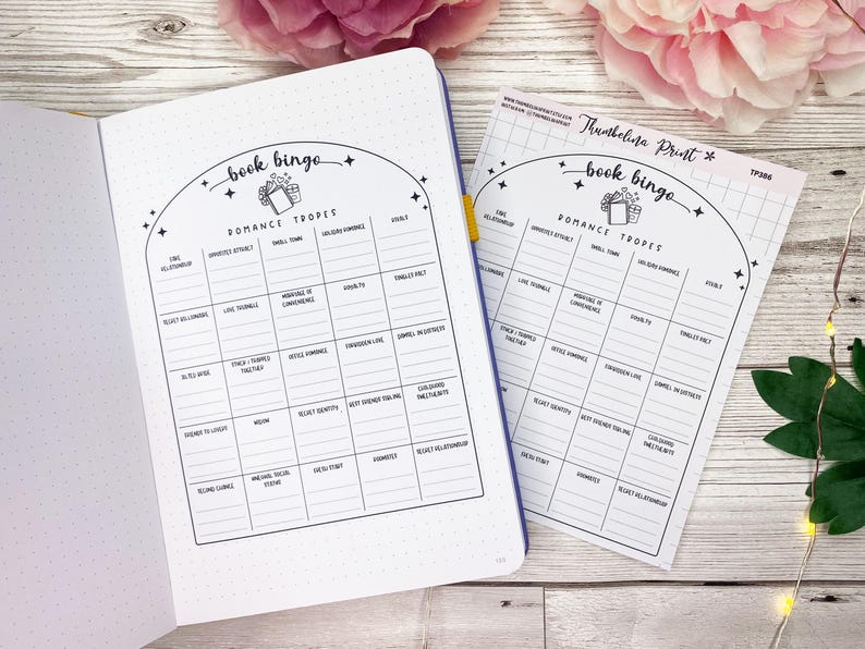 May include: A printable book bingo card with a black and white design. The card features a list of romance tropes, including "fake relationship", "enemies to lovers", and "forced proximity".