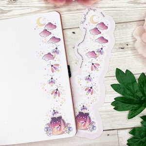 Op de afbeelding: Twee vellen met stickers met een grillig ontwerp van vuurvliegjes, wolken en een maan. De stickers zijn gedrukt op wit papier met een roze achtergrond. De tekst op het stickervel luidt "The Darling Print".