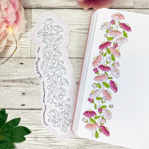 Könnte beinhalten: Zwei Blumenaufkleber, einer mit einer Reihe von rosa und weißen Blumen und der andere mit einer Reihe von weißen Blumen. Die Aufkleber befinden sich auf einer weißen Holzoberfläche.