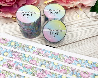 May include: Four rolls of washi tape with a floral design and the text "Thumbelina Print" on the label. The tape is on a wooden surface.