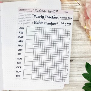 May include: A black and white printable habit tracker with a grid of squares for each day of the year. The months are listed on the left side of the grid. The text "Yearly Tracker" and "Habit Tracker" are printed at the top of the page. The text "Color Key" is printed twice on the right side of the page.
