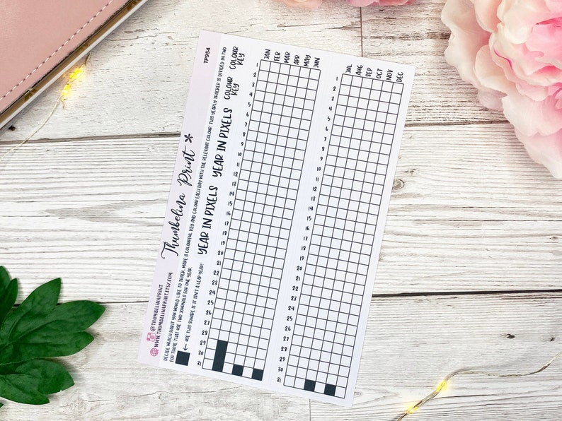 May include: A printable year in pixels tracker with a grid of 31 squares for each month. The tracker is designed to be used for tracking goals, habits, or other activities.
