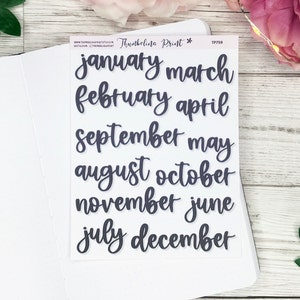 Op de afbeelding: Een vel stickers met de maanden van het jaar geschreven in een handschrift. De stickers zijn gedrukt op een transparante achtergrond en zijn klaar om te gebruiken in een planner of dagboek.