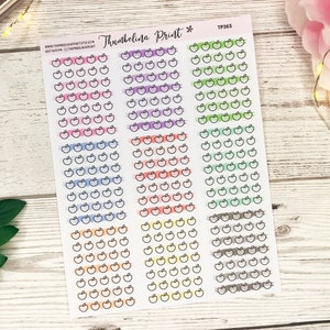 May include: A sheet of stickers with multiple rows of apple icons. Each row has a different colour background, including pink, purple, orange, green, yellow, and grey.
