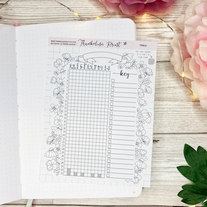 May include: A black and white printable planner page with a floral border. The page is divided into a grid with numbers 1-31 and a key with blank lines for writing. The text "Thumbelina Print" is at the top of the page.