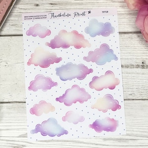 Op de afbeelding: Een vel stickers met 15 aquarel-achtige wolken in tinten van paars, roze en blauw. De wolken bevinden zich op een witte achtergrond met kleine blauwe stippen. Het vel is gelabeld met "Thumbelina Print*" en "TP719".
