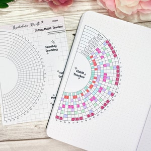 May include: A 31-day habit tracker with a semi-circular grid, filled with colorful squares. The tracker is open in a dotted notebook, with a matching printed sheet beside it. The text "Thursbelina Print" and "31 Day Habit Tracker" are visible.