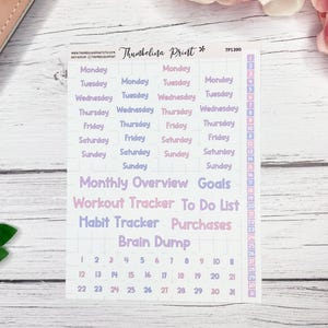 May include: A sheet of planner stickers with a white background and text in shades of purple and pink. The stickers include days of the week, dates, and labels like "Goals" and "Workout Tracker."
