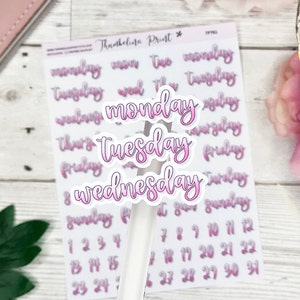 May include: A sheet of planner stickers with days of the week and numbers. The days of the week are in a pink script font with a white outline. The numbers are in a smaller, pink font.