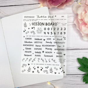 Op de afbeelding: Een transparante Vision Board-sticker met zwarte tekst en decoratieve elementen, waaronder harten, sterren en pijlen. De sticker bevat categorieën als "Carrière", "Hobby's" en cijfers voor planning.