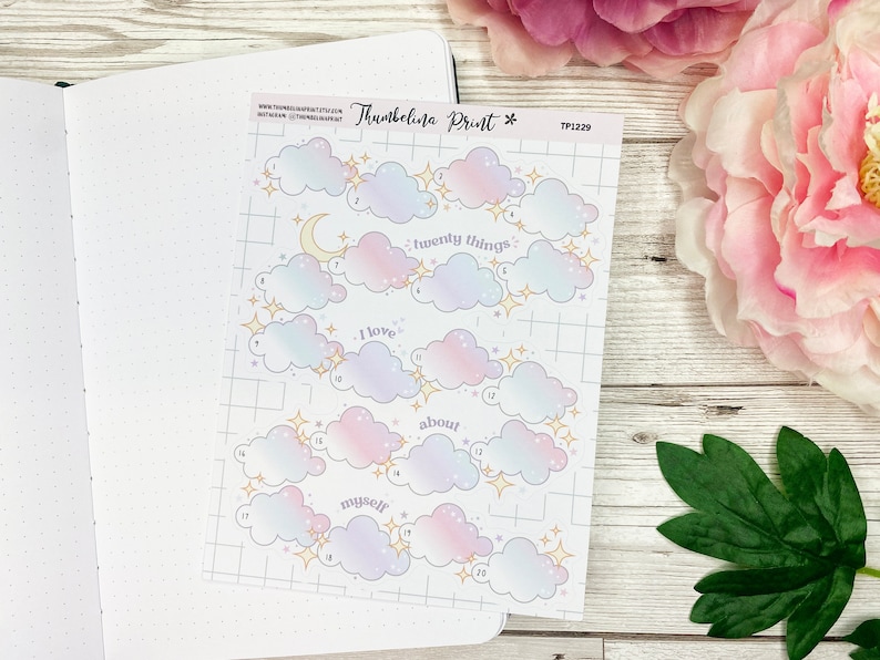 May include: A sheet of twenty cloud-shaped stickers with a pastel pink and blue ombre design. Each cloud has a number and a gold star. The text "I love twenty things about myself" is printed on the sheet.