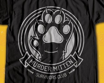 Puede incluir: Camiseta negra con un gráfico blanco de una huella de pata de gato dentro de un círculo con el texto "Murder Mitten Survivors Club".