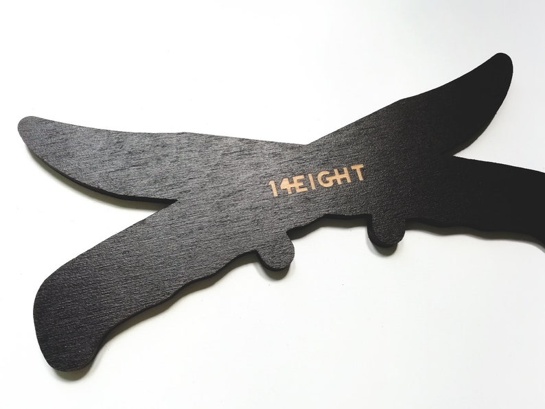May include: Black wooden cutout of a plane with the text "14 EIGHT" printed on it.