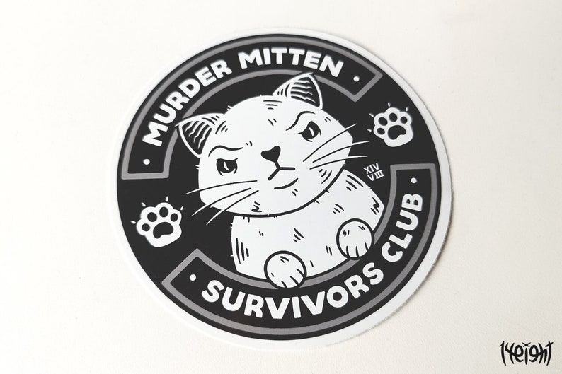 Pu&ograve; includere: Adesivo bianco e nero con un gatto dei cartoni animati con un'espressione scontrosa. L'adesivo dice "Murder Mitten Survivors Club" con impronte di zampe su entrambi i lati.
