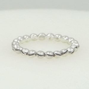 Peut inclure: Une bague en argent avec un design perlé. La bague est faite de petites perles rondes qui sont espacées uniformément.