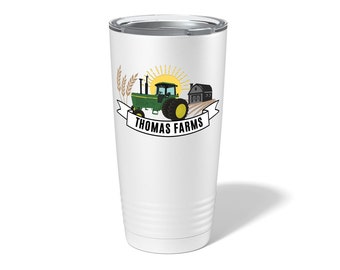 Könnte beinhalten: Ein weißer Edelstahlbecher mit einem grünen Traktor, einem Schuppen und einem Sonnenmotiv. Der Text "THOMAS FARMS" befindet sich auf einem Banner unter dem Motiv.