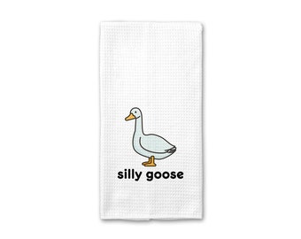 Könnte beinhalten: Weißes Küchentuch mit einer Cartoon-Illustration einer Gans und dem Text "silly goose".