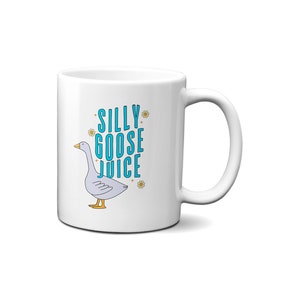 May include: White ceramic mug with a blue and white illustration of a goose and the text "Silly Goose Juice".