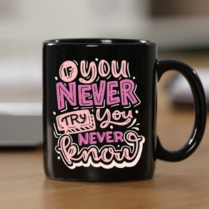 May include: Black coffee mug with a pink and white inspirational quote that reads "If you never try you never know".