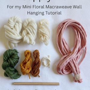 May include: A craft supply kit for a mini floral macraweave wall hanging, featuring text that reads Supply Kit For my Mini Floral Macraweave Wall Hanging Tutorial and Includes supplies seen above, pre-cut. Supplies will make one wall hanging. The kit contains various colors of yarn, including white, green, mustard, brown, and a large bundle of pink cord, along with a single wooden dowel.