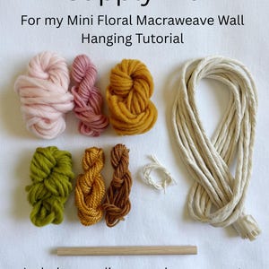 May include: A supply kit for a mini floral macraweave wall hanging, featuring text that reads Supply Kit For my Mini Floral Macraweave Wall Hanging Tutorial and Includes supplies seen above, pre-cut. Supplies will make one wall hanging. Includes yarn in pink, mauve, mustard, olive, gold, and brown, a coil of white string, a long length of thick cream cord, and a wooden dowel.