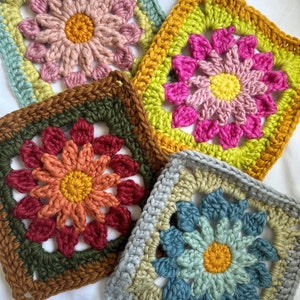 May include: Four crocheted granny squares with different colored flowers in the center. The squares are in shades of blue, green, pink, and orange.