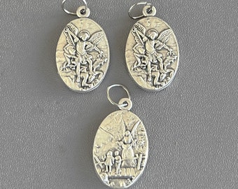 May include: Three silver oval pendants with religious imagery. The pendants feature an angel with wings and a halo. One pendant depicts the angel protecting two children.