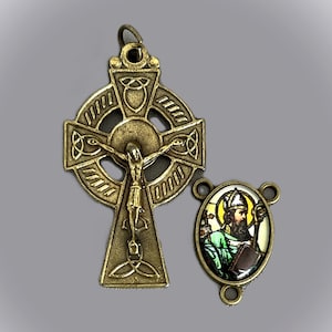 May include: A bronze Celtic cross pendant with a crucifix and a stained glass image of Saint Patrick. The cross is decorated with Celtic knotwork.