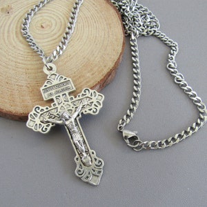 May include: Silver chain necklace with a detailed silver crucifix pendant. The crucifix features the inscription "JESUS NAZARENUS REX JUDAEORUM".