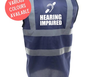 May include: A navy blue safety vest with reflective silver stripes and the text "HEARING IMPAIRED" in white with a white symbol of a hearing aid. The vest is available in various colors.