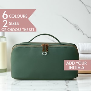 Peut inclure: Une trousse de maquillage vert foncé avec une fermeture éclair et une poignée dorées. Le sac porte les initiales "CG" sur le devant. Le texte sur l'image indique "6 couleurs, 2 tailles, ou choisissez l'ensemble" et "Ajoutez vos initiales".